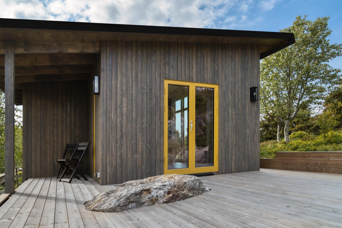 Attefallshus med färgstarka fönsterdörrar i trä-aluminium