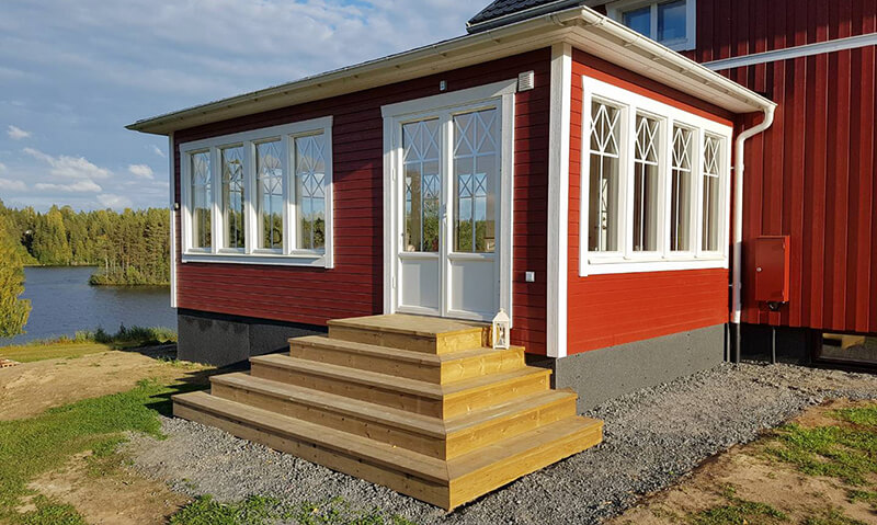 Referensbild på en parfönsterdörr i trä i anslutning till likadana fönster.