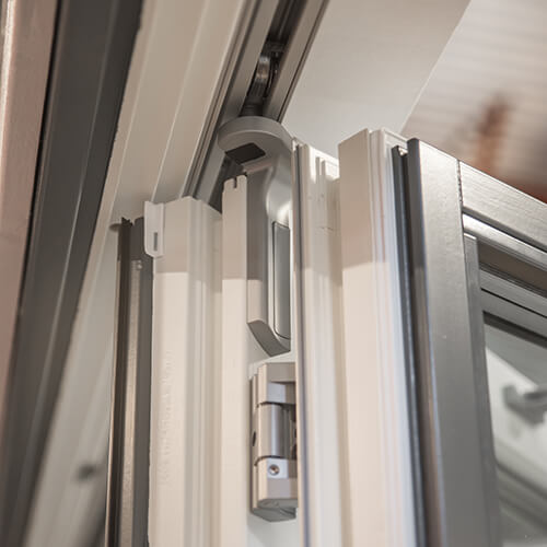 Detaljbild på ovansidan/skenan på vikdörr i trä