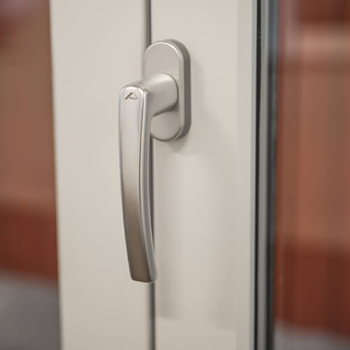 Handtag som sitter på de vikbara delarna på en vikdörr i trä.